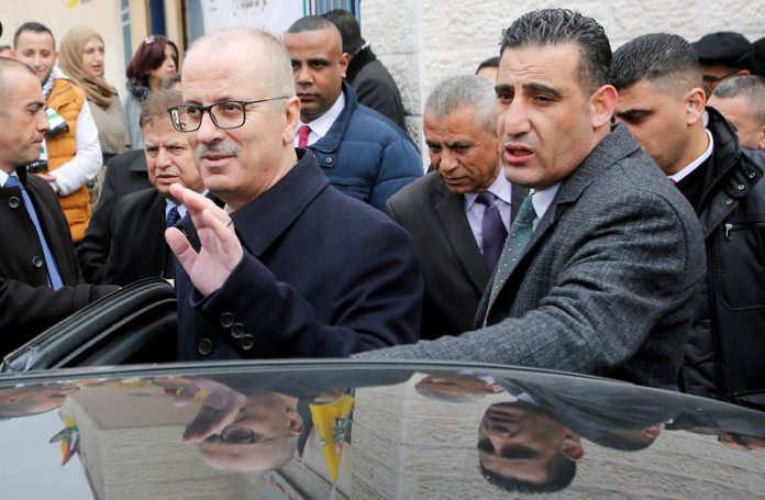 FILE PHOTO: Palestinian Prime Minister Rami Hamdallah Waves As He Leaves After Attending The Opening Ceremony Of A Health Center Near Hebron, In The Israeli Occupied West Bank
