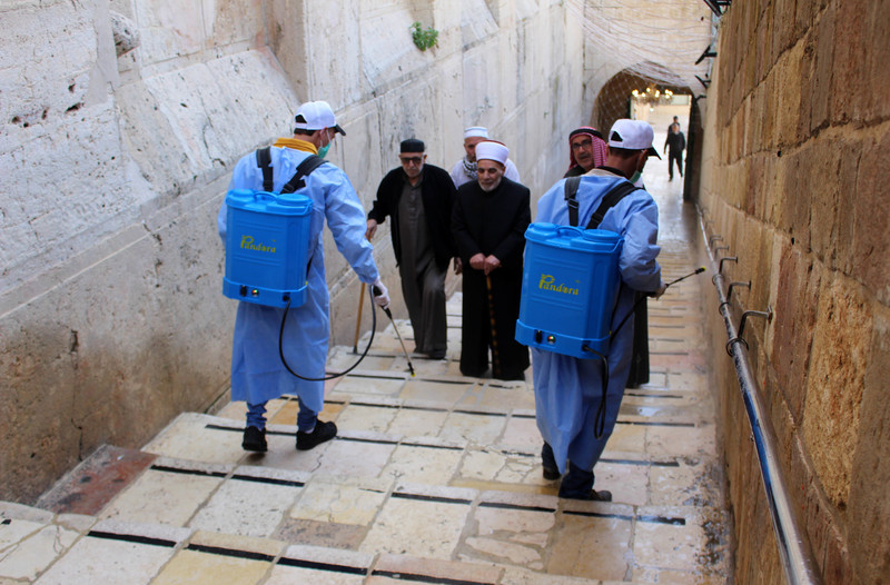 Palestinian workers disinfect gates and barriers near the near the Ibrahimi mosque in the Old city of the West Bank city of Hebron as a preventive measure amid fears of the spread of the novel coronavirus, on March 11, 2020. Photo: Mosab Shawer