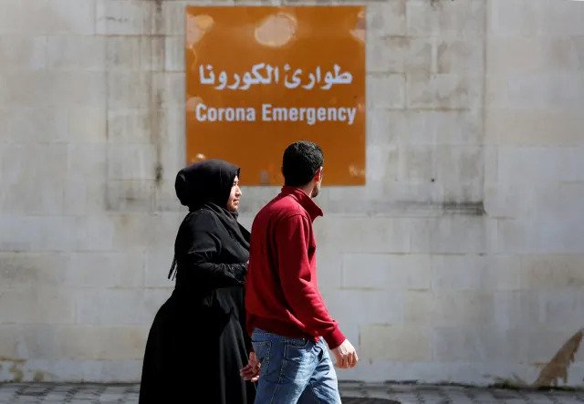 People pass in front of the emergency entrance of the government-run Rafik Hariri Hospital, Beirut, Lebanon, March 11, 2020 (Hussein Malla, AP)