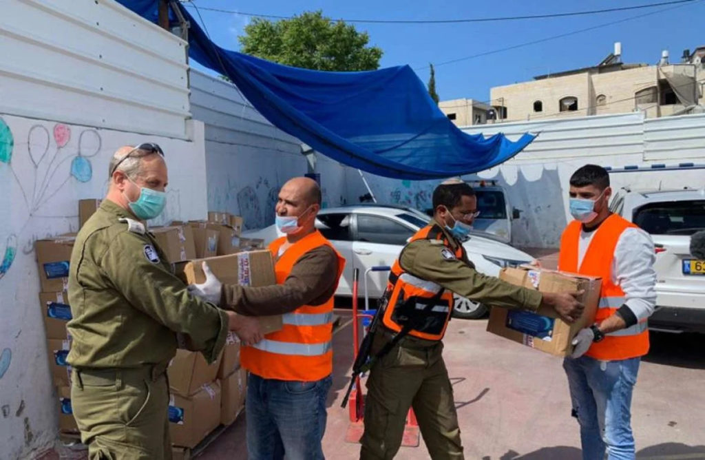Israeli soldiers and Palestinian volunteers work together to deliver food and medical supplies in east Jerusalem