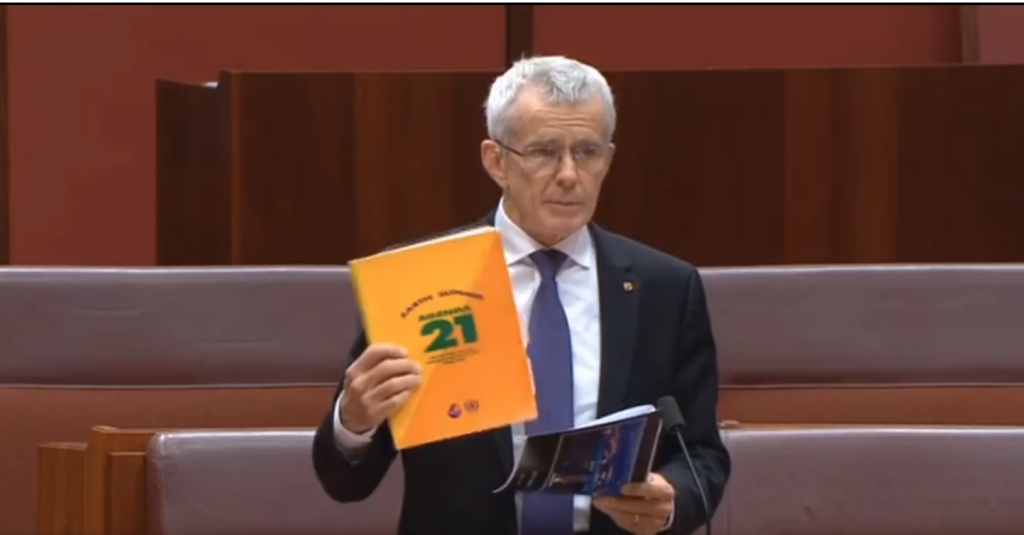 Senator Malcolm Roberts holds a copy of Agenda 21.