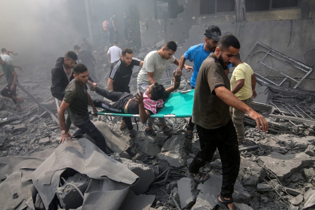 Palestinians an injured man after an Israeli airstrike in Rafah, Gaza (Image: Anas Mohammed/ Shutterstock)