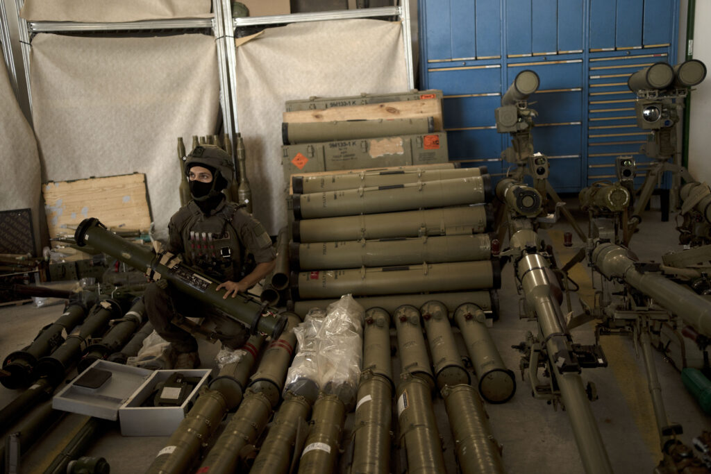 An Israeli soldier from an EOD (explosive ordnance disposal) unit poses with a weapon used by Hezbollah seized during combat operations in Lebanon at a base in southern Israel, Oct. 9, 2024. (Image: AP Photo/Maya Alleruzzo)