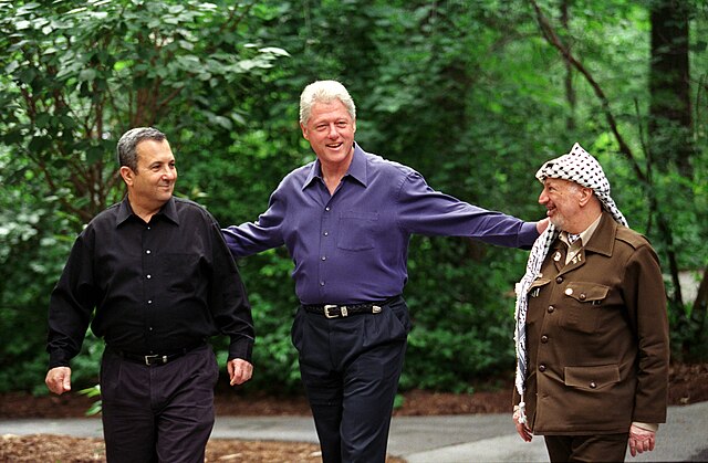 President Bill Clinton walks Prime Minister Ehud Barak of Israel and Yasser Arafat of the Palestinian Authority at Camp David, Maryland, July 2000 (Image: Wikipedia)