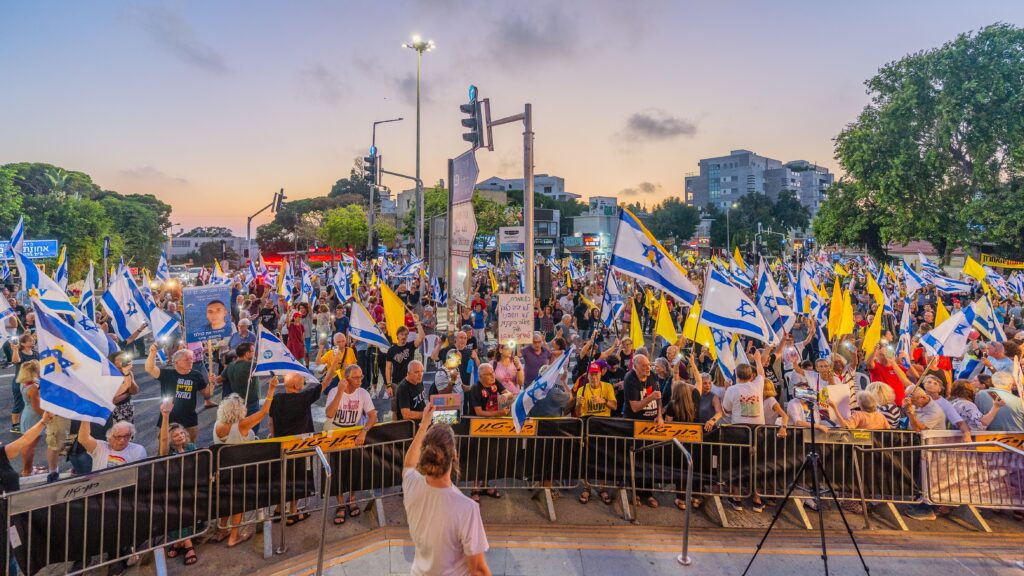 Israelis in Haifa with various signs and flags take part in a protest rally calling for end the war, completion of the hostage deal and new elections (Image: Shutterstock)