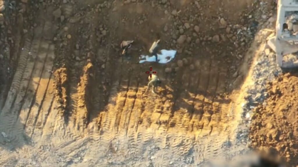 Israeli military drone video shows Hamas operatives burying a white shroud containing hostage remains in Gaza City and then staging its discovery in front of the Red Cross (IDF video screenshot)