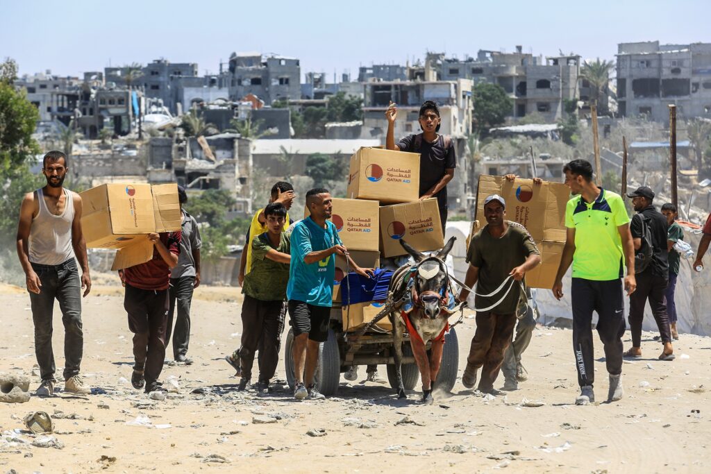 Palestinians carrying food aid received from an aid point in Rafah, southern Gaza Strip (Image: Shutterstock/ Anas Mohammed)