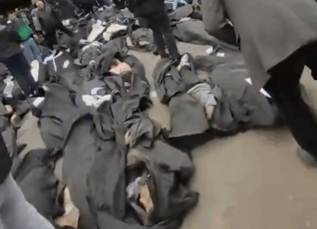 Iranians gather around the bodies of murdered protesters (Image: Screenshot)