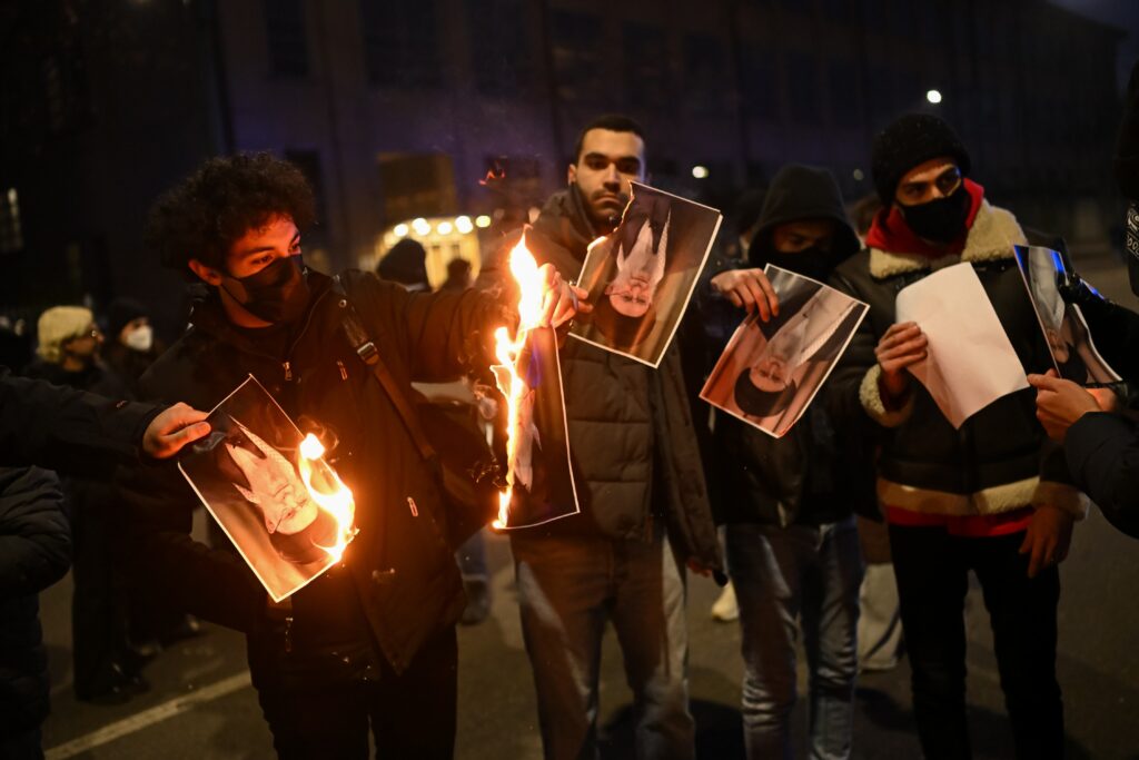 Protesters burn a photo depicting Ali Khamenei, Supreme Leader of Iran (Image: Shutterstock)