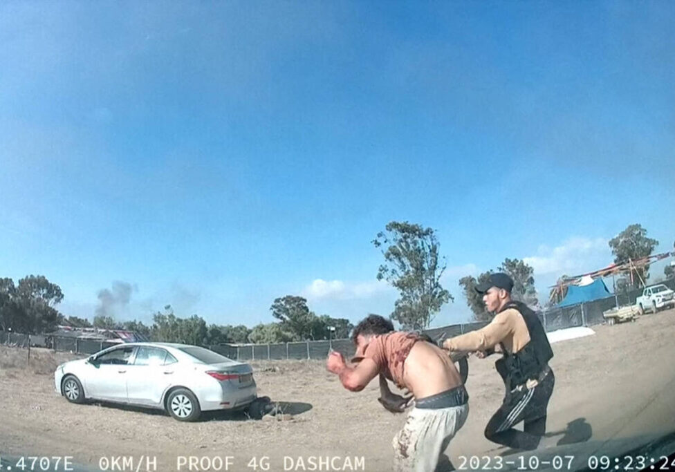 A Hamas terrorist and a captured man at the Nova festival on October 7, 2023 (Image: Video footage posted on the Telegram channel South First Responders)