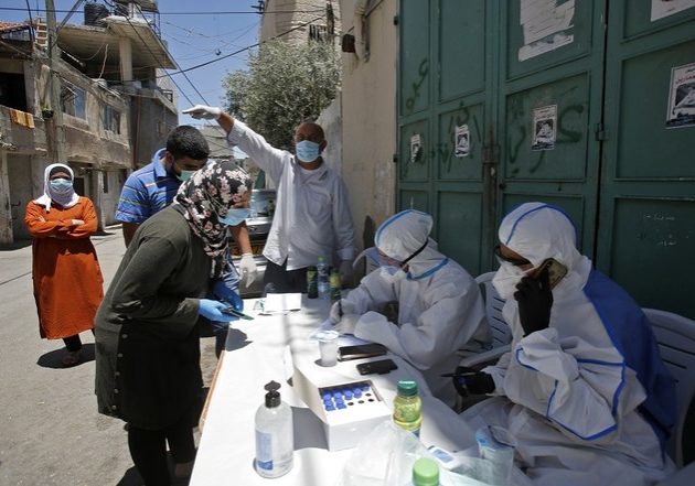 Medical workers affiliated with the Palestinian health ministry collect samples to test for the Covid-19 coronavirus in a mobile position in al-Azza Refugee Camp in the West Bank city of Bethlehem, on June 24, 2020 (Photo by Musa Al SHAER / AFP)