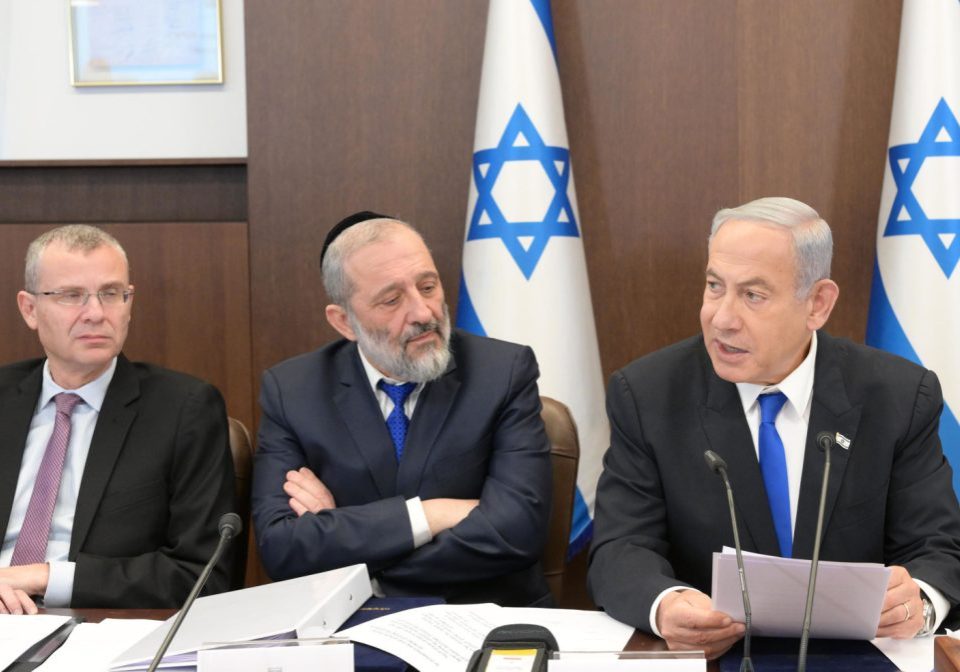 Netanyahu and Deri (right and centre), both of whom face legal troubles, sit alongside Justice Minister Yariv Levin (left), the author of controversial proposed judicial reforms, at a cabinet meeting (Image: IGPO/Flickr)