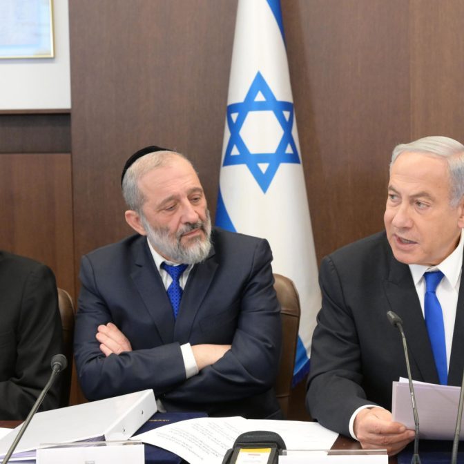 Netanyahu and Deri (right and centre), both of whom face legal troubles, sit alongside Justice Minister Yariv Levin (left), the author of controversial proposed judicial reforms, at a cabinet meeting (Image: IGPO/Flickr)