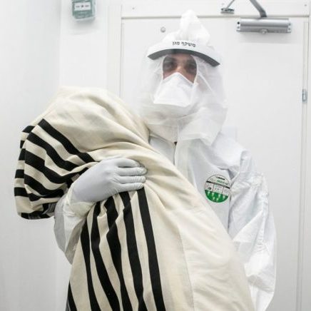 Dr. Abed Zahalka bringing a Torah scroll into the coronavirus unit at Mayanei Hayeshua Medical Centre in Bnei Brak