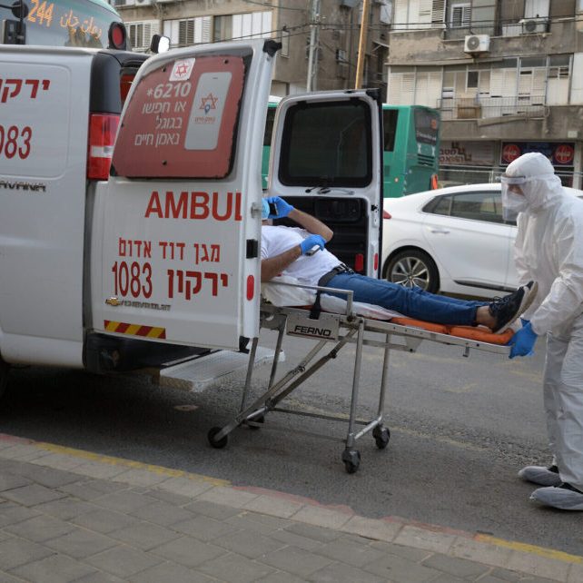 Israeli Magen David Adom medical team members transfer an Israeli man, suspected of being Covid-19 positive, in the Ultra-Orthodox Jewish city of Bnei Brak. Photo by Gili Yaari/Flash90
