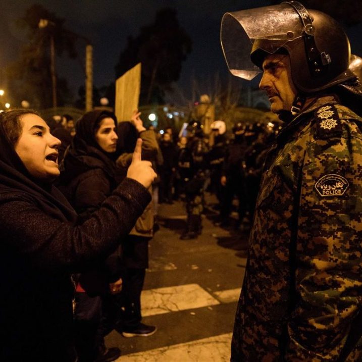 A woman attending a candlelight vigil for the victims of the Ukraine International Airlines flight 752 tragedy confronts a police officer at Amirkabir University in Teheran (Mona Hoobehfekr/ISNA/AFP/Getty)