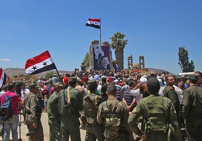 Syrian troops raise the Syrian flag in the border town of Quneitra in the Syrian Golan Heights on July 27, 2018 (AFP Photo/Youssef Karwashan) as the Syrian armed forces, aligned with Iran and its proxies, return to Israel's Golan border