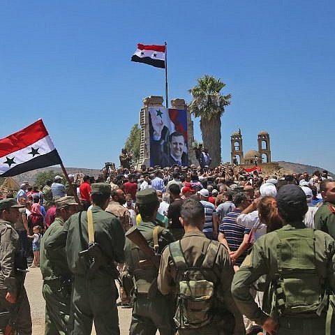 Syrian troops raise the Syrian flag in the border town of Quneitra in the Syrian Golan Heights on July 27, 2018 (AFP Photo/Youssef Karwashan) as the Syrian armed forces, aligned with Iran and its proxies, return to Israel's Golan border