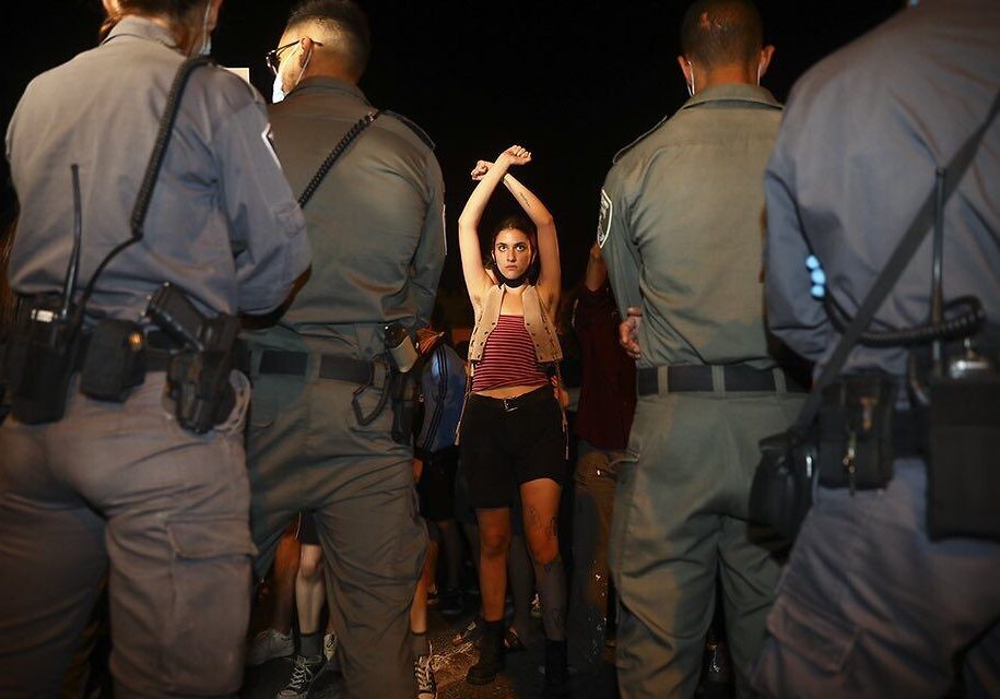 A protester faces police during a demonstration against Prime Minister Benjamin Netanyahu in Jerusalem, July 18, 2020 (AP Photo/Oded Balilty)