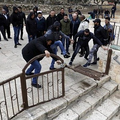 Palestinian demonstrators break open the locked entrance to the Gate of Mercy compound outside the Al Aqsa Mosque on the Temple Mount in Jerusalem's Old City, February 18, 2019. (Ahmad Gharabli/AFP)