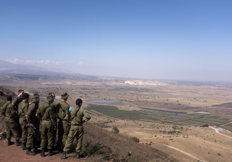 Israeli soldiers look out towards southern Syria from the strategic Golan Heights plateau