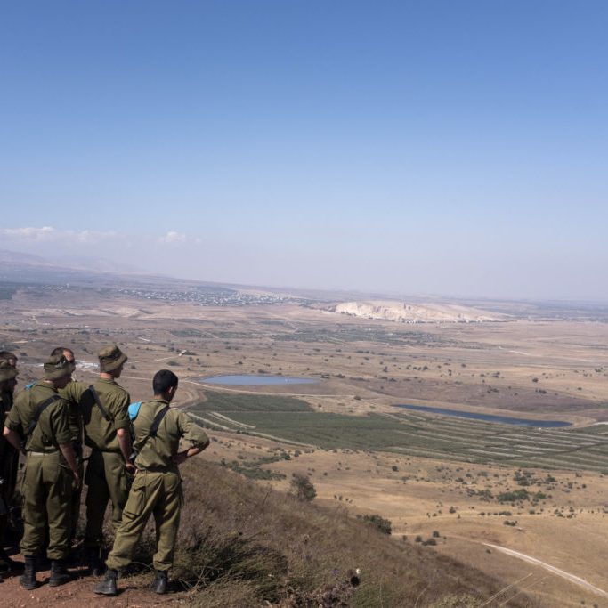Israeli soldiers look out towards southern Syria from the strategic Golan Heights plateau