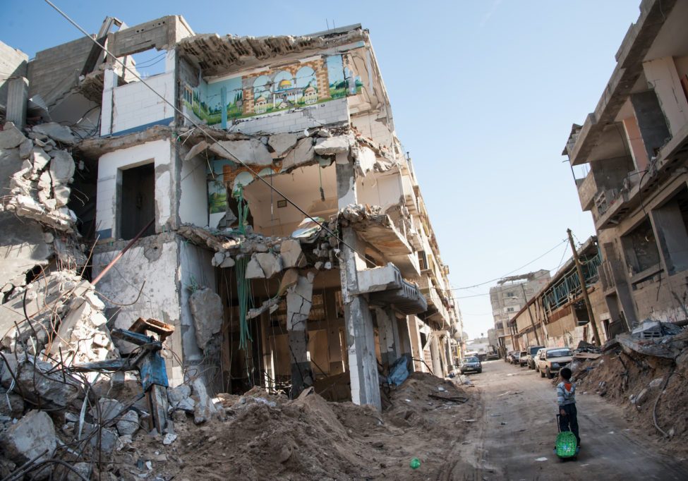 A child passes a bombed-out residential block in the Al-Zeitoun neighborhood of Gaza City (Credit: Ryan Rodrick Beiler/Shutterstock)