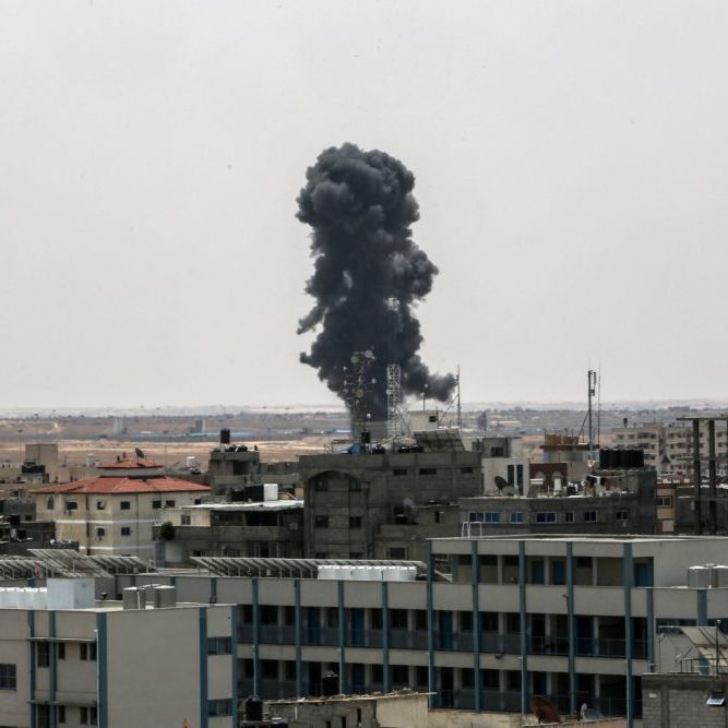 Smoke rises above buildings after air strikes by Israeli warplanes, in the southern Gaza Strip, on May 12, 2023 (Image: Shutterstock)