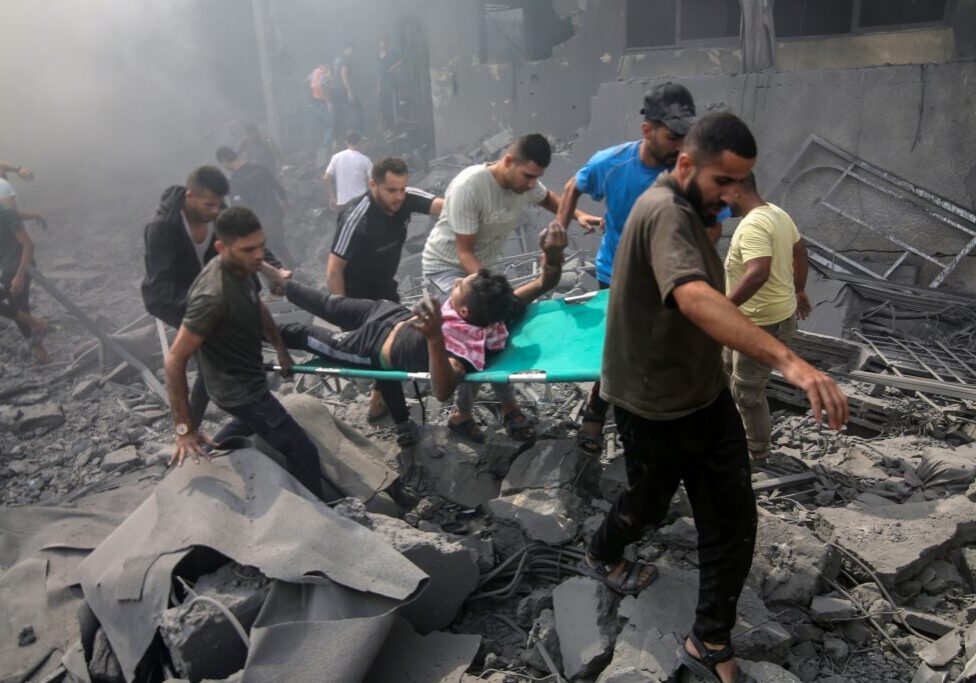 Palestinians an injured man after an Israeli airstrike in Rafah, Gaza (Image: Anas Mohammed/ Shutterstock)