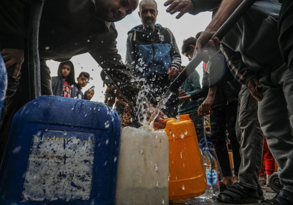Palestinians distribute drinking water to displaced people in Gaza City (Image: Anas Mohammed/ Shutterstock)