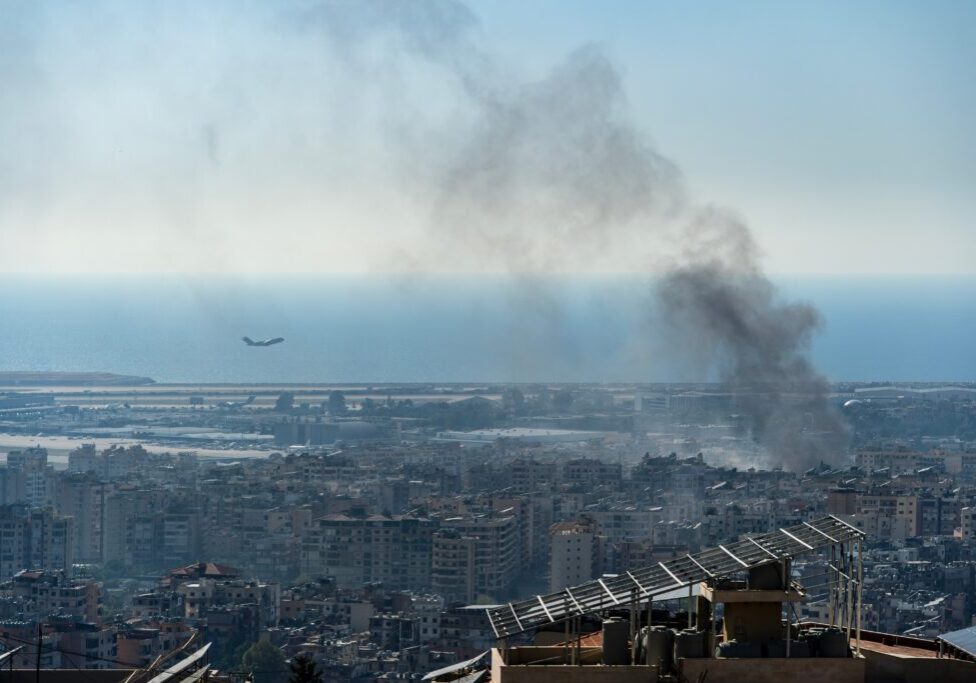 A plane takes off from Beirut International Airport as smoke rises from airstrike on Beirut southern suburbs, amid ongoing war between Hezbollah and Israel (Image: Ali Chehade Farhat/ Shutterstock)