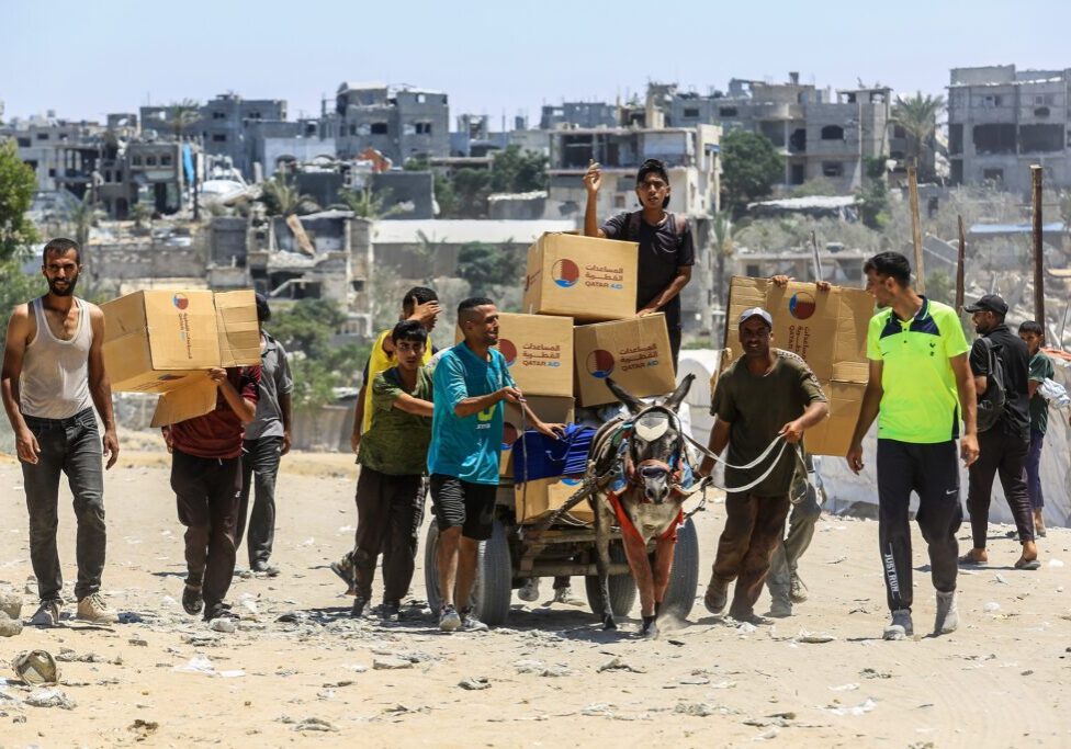 Palestinians carrying food aid received from an aid point in Rafah, southern Gaza Strip (Image: Shutterstock/ Anas Mohammed)