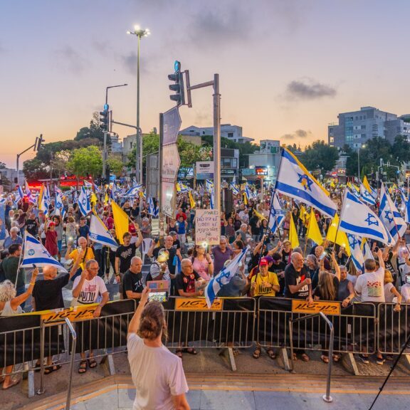 Israelis in Haifa with various signs and flags take part in a protest rally calling for end the war, completion of the hostage deal and new elections (Image: Shutterstock)
