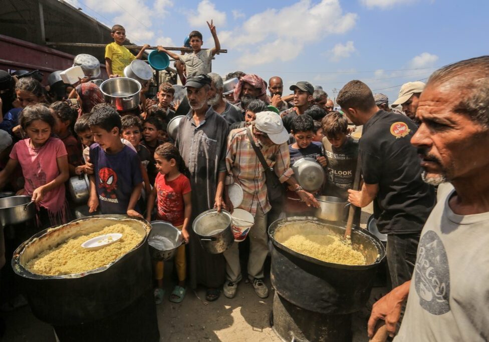 Palestinians receive meals from the charity kitchen in Khan Yunis, southern Gaza Strip, on August 21, 2025 (Image: Anas Mohammed/ Shutterstock)