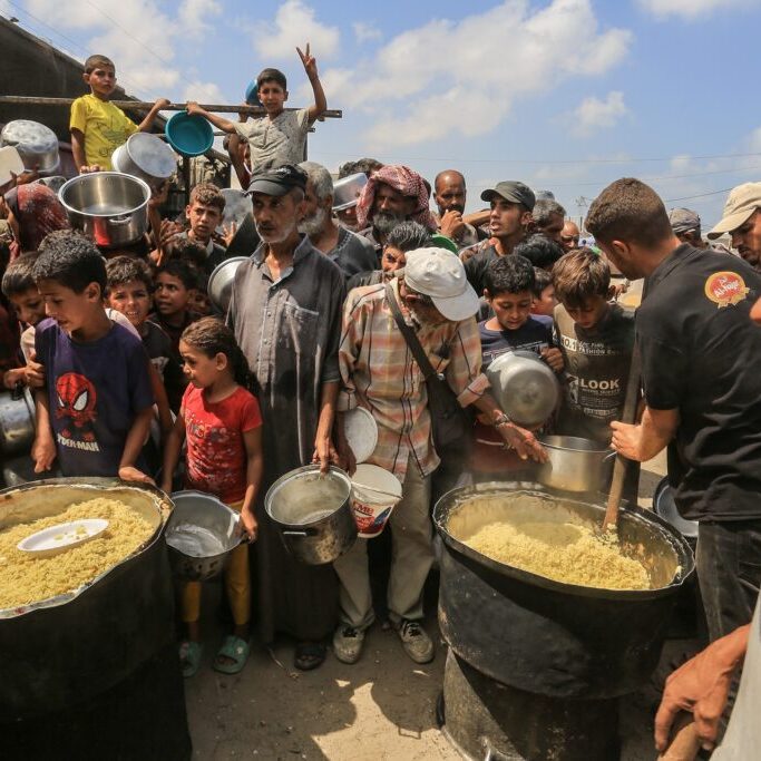Palestinians receive meals from the charity kitchen in Khan Yunis, southern Gaza Strip, on August 21, 2025 (Image: Anas Mohammed/ Shutterstock)
