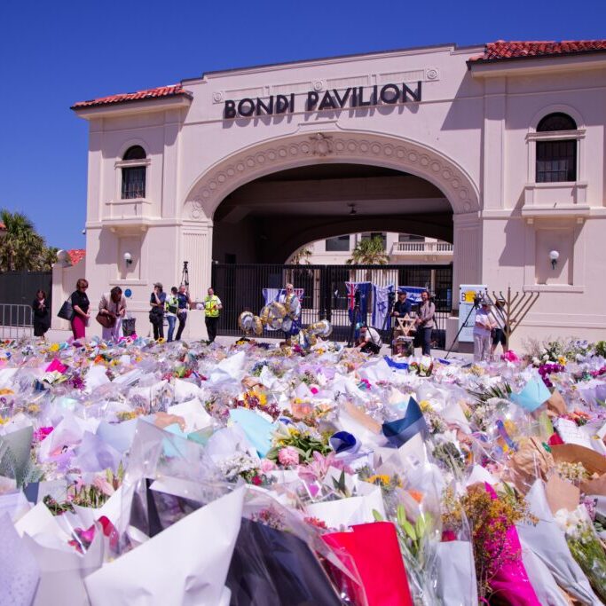 People gather at a flower memorial for the victims outside the Bondi Pavilion in Sydney (Image: Shutterstock)