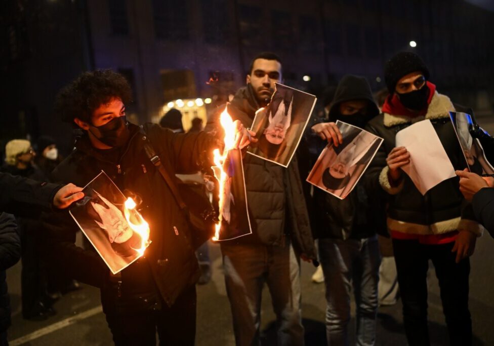 Protesters burn a photo depicting Ali Khamenei, Supreme Leader of Iran (Image: Shutterstock)