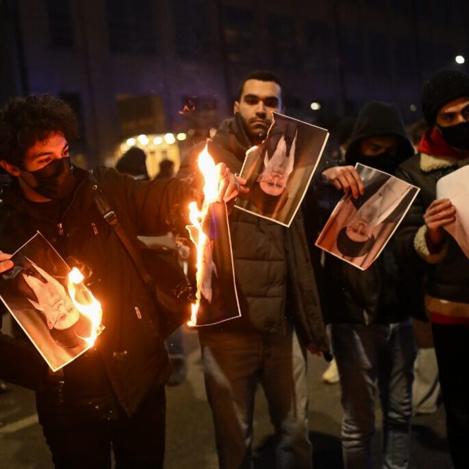 Protesters burn a photo depicting Ali Khamenei, Supreme Leader of Iran (Image: Shutterstock)